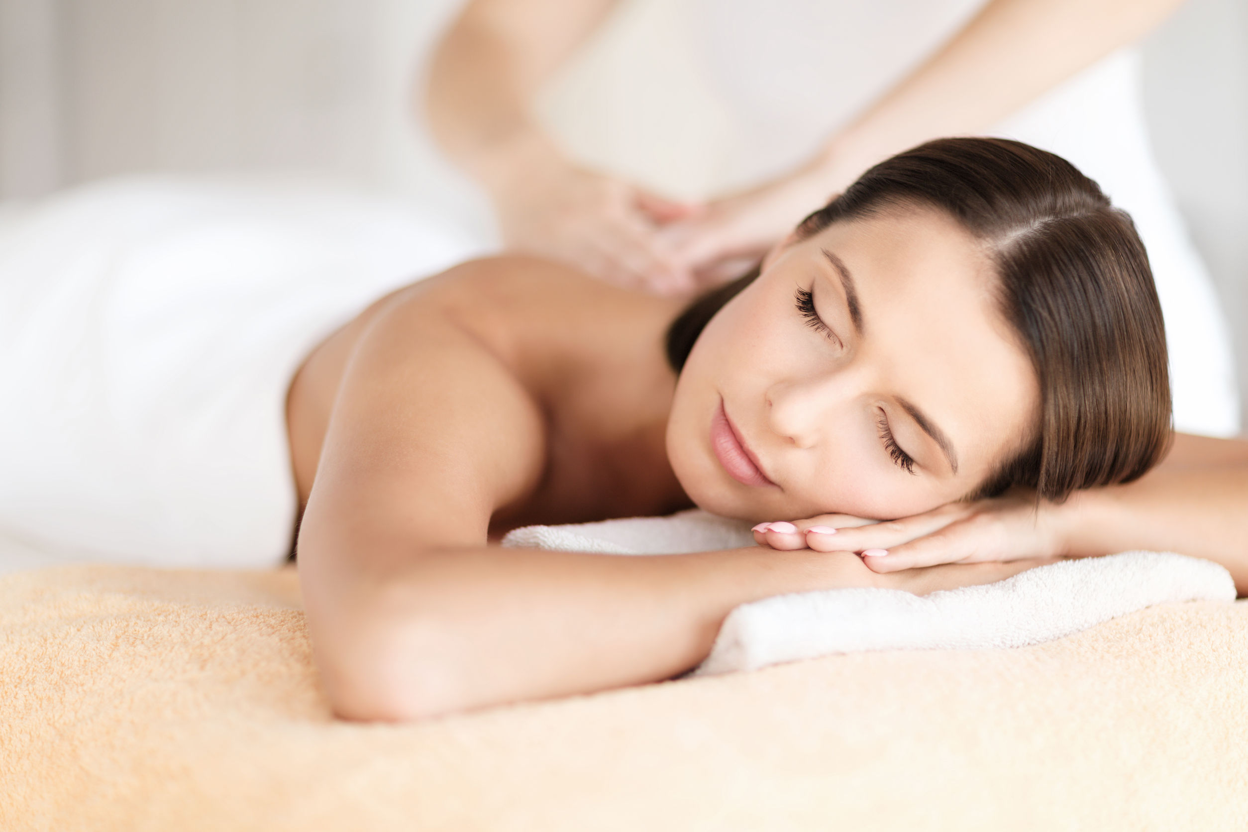35173934 - health, beauty, resort and relaxation concept - beautiful woman with closed eyes in spa salon getting massage